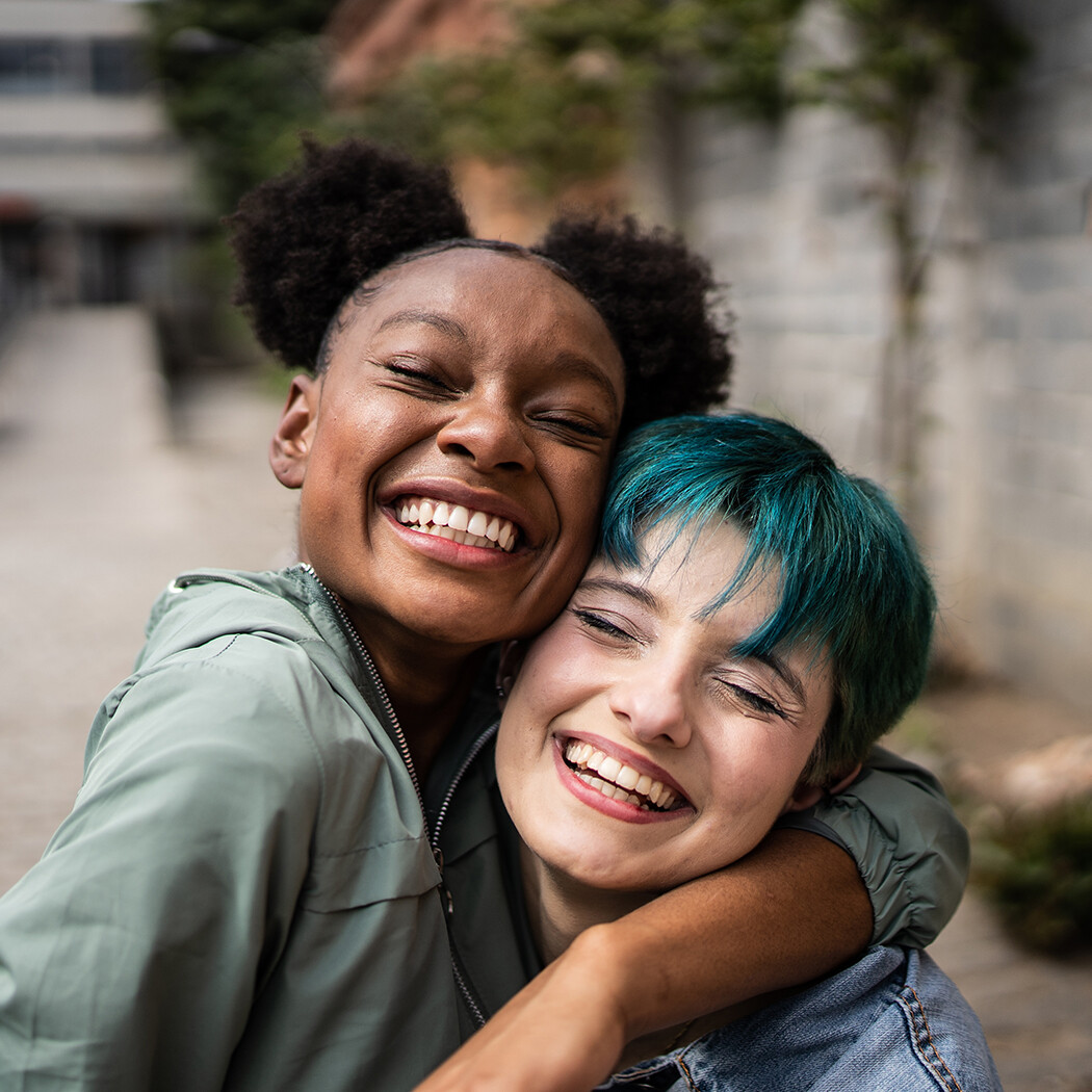 Two women hugging smiling